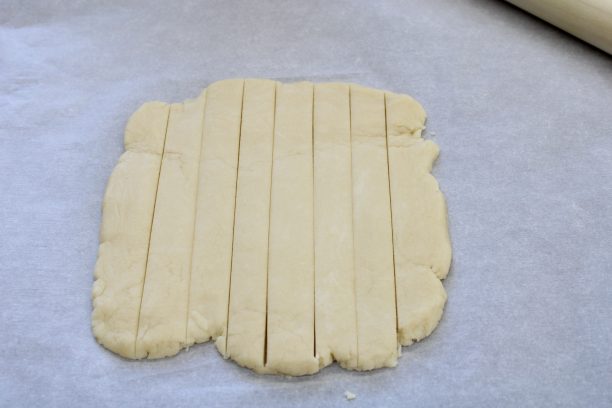 台に打ち粉をし、生地を麺棒で厚さ1㎝ほどに伸ばし縦8等分に切ります。細長くなるように成形します。