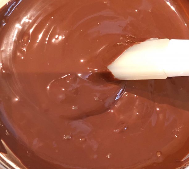 細かく砕いたチョコレートをボウルに入れ溶かします。
オーブンレンジに温度設定機能があれば、50度に設定してチンするとキレイにチョコが溶けます。
なければ湯煎して下さいね。