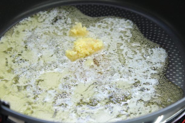 フライパンにバターを入れ中火で溶かし、おろしにんにく、おろし生姜を加えて、香りが出るまで炒めます。