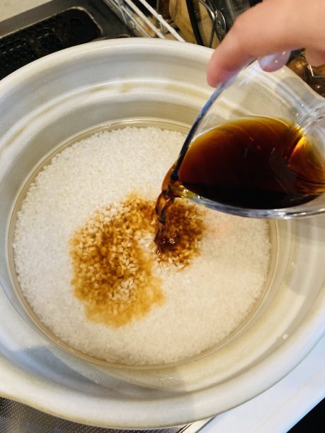 米と水が入った釜に酒と醤油を入れる