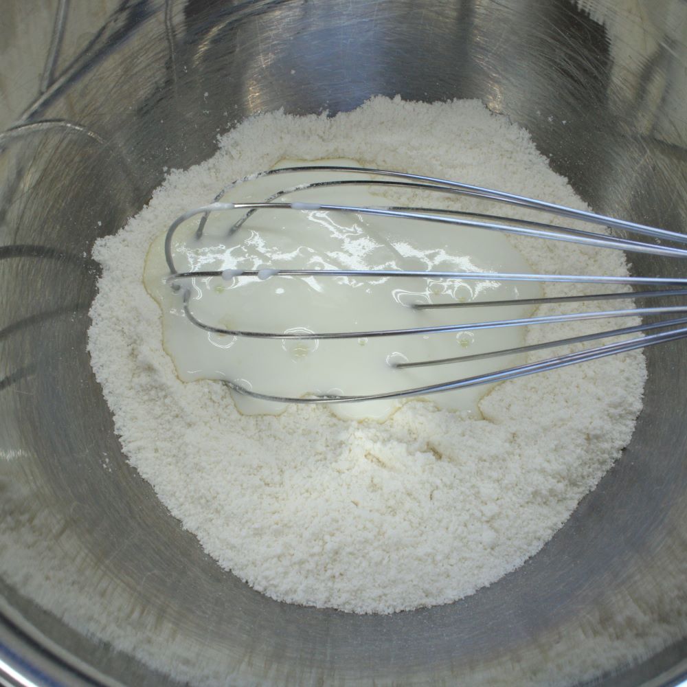 ボウルに薄力粉、強力粉、グラニュー糖を入れ、泡立て器でかき混ぜます。②を入れ、なめらかになるまで混ぜます。