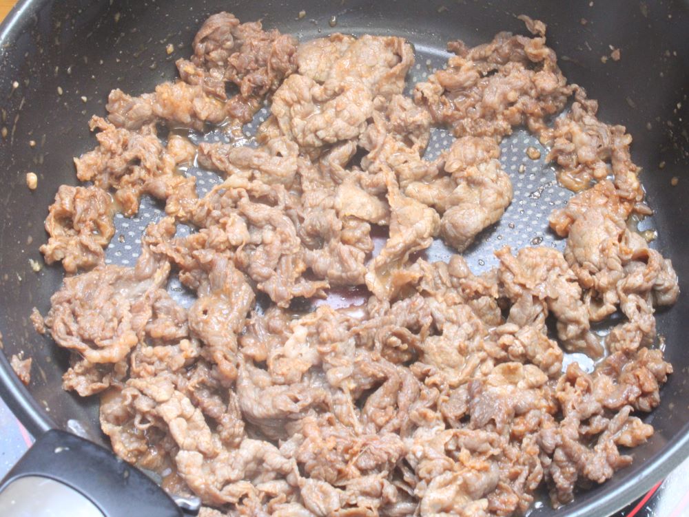 中火で熱したフライパンに漬け込んだ牛こま肉を入れ、ほぐしながら炒めます