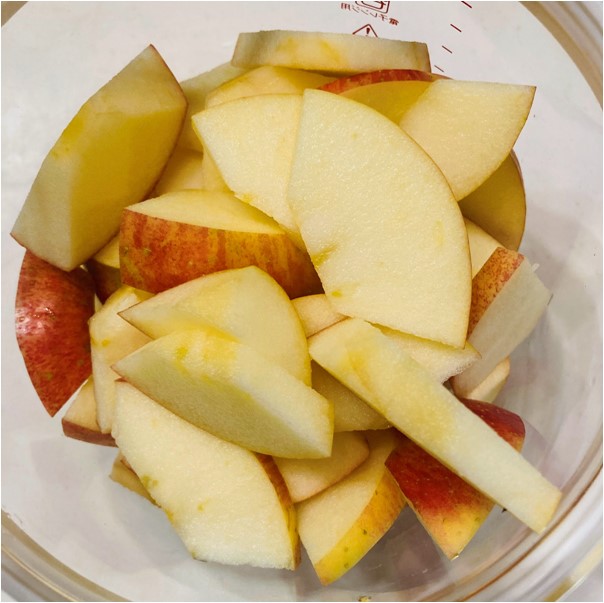 消毒したヨーグルティアのガラス容器に、切り分けたリンゴを入れます。