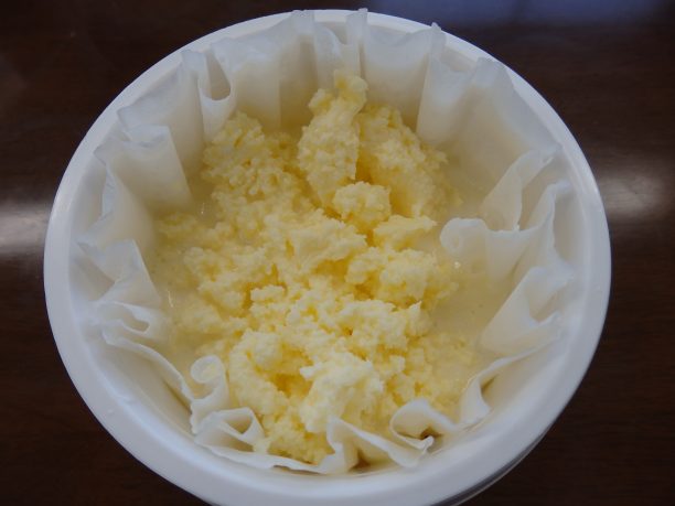 ハサミでペットボトルを切り、バターをキッチンペーパーにのせて水分を取ります。