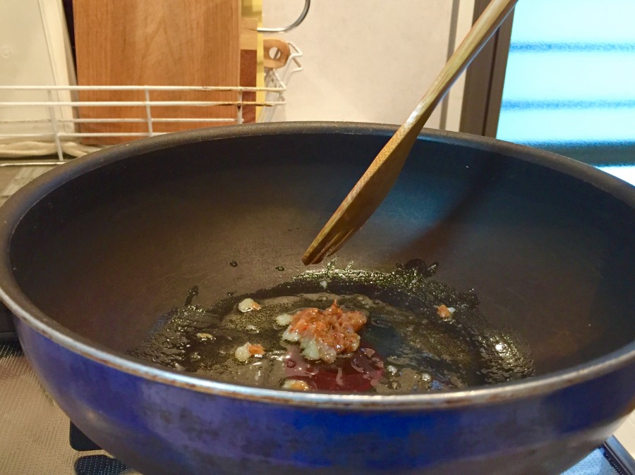 フライパンに、ごま油、コチュジャン、すりおろしニンニクを入れて中火で炒めます。