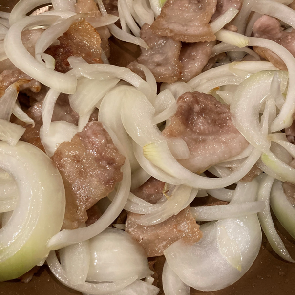 豚バラ肉の色が変わったら玉ねぎを入れて炒めます。