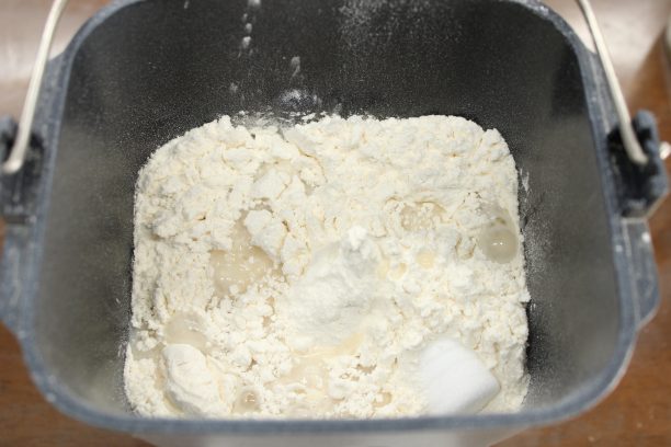 ホームベーカリーの内容器の中に、出来上がった天然酵母30ｇと、パンの材料(●)を上から順に加えていきます。