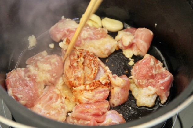 ダッチオーブンでオリーブオイルを熱し、鶏モモ肉を皮側から焼きます。
