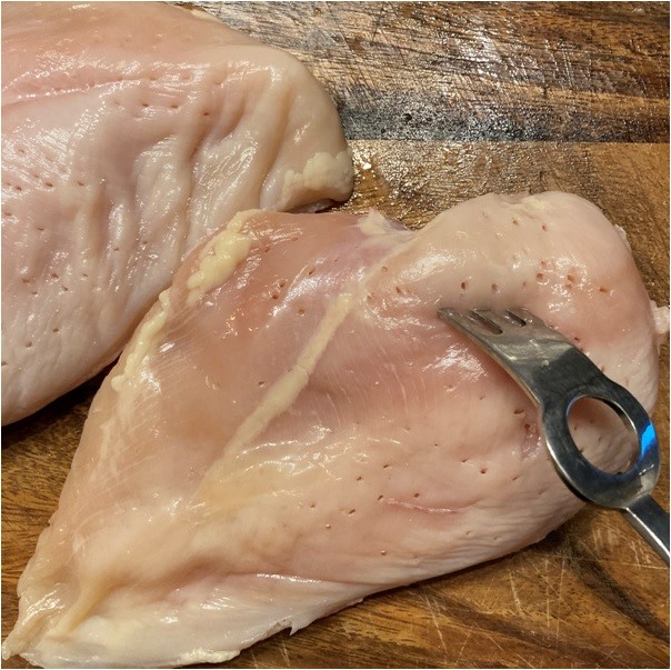 鶏むね肉を広げフォークでブスブス穴を開けます。（皮は取り除きましたが、お好みでつけたままでも大丈夫です。）
