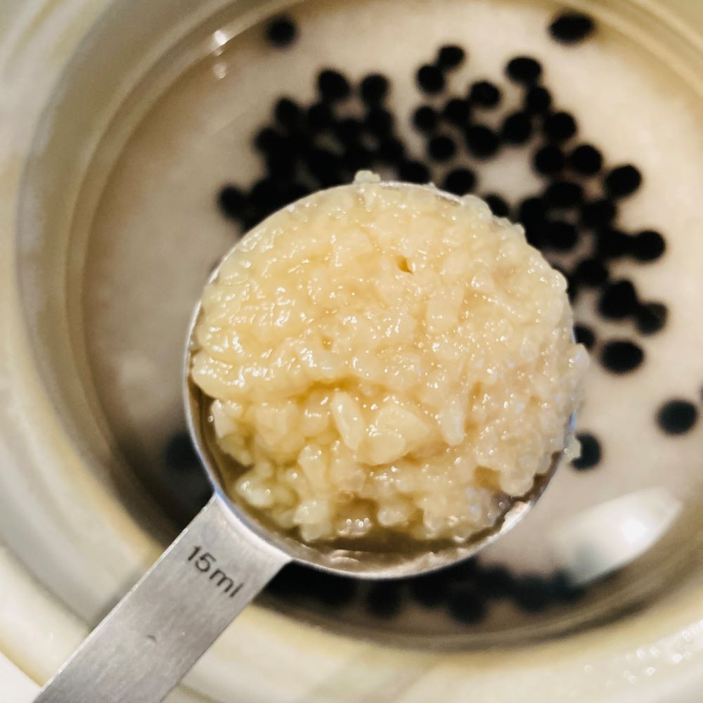 お釜に研いだ米、黒豆、2合分の水、足し水、塩こうじを入れてよくかき混ぜます